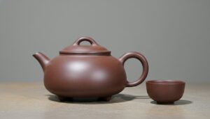 Rounded Shi Piao Yixing purple clay teapot with low body, small feet, straight spout, and arched lid knob