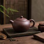 Yixing-style purple clay teapot with a subtle natural patina on a tea table